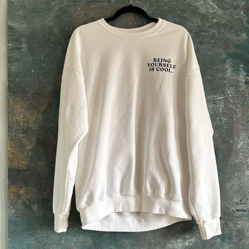Dressed in LALA “Being Yourself is Cool” white crew neck sweatshirt